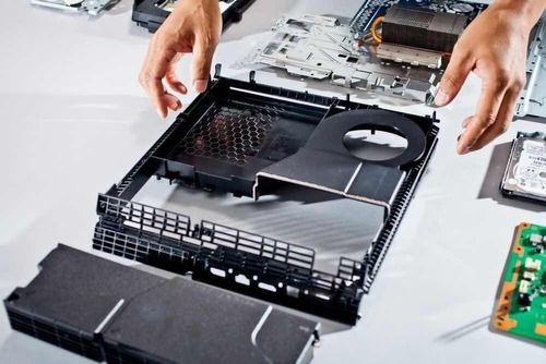 Técnico de Playnet realizando una reparación compleja de microsoldadura en una placa de PlayStation