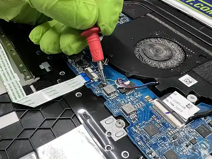 Técnico de Playnet trabajando con microscopio en una reparación de alta complejidad en una placa madre